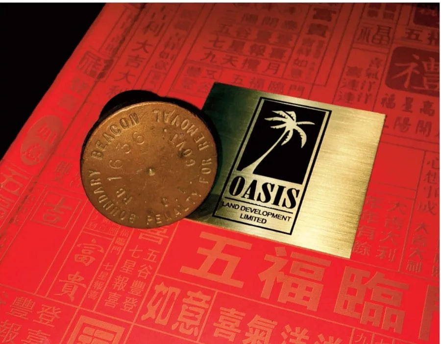 Example numbered brass boundary cap beside an Oasis plate; not photographed on this lot