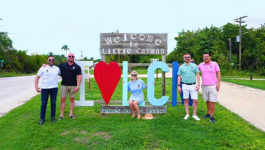 The Oasis Land Development team at the Welcome to Little Cayman sign