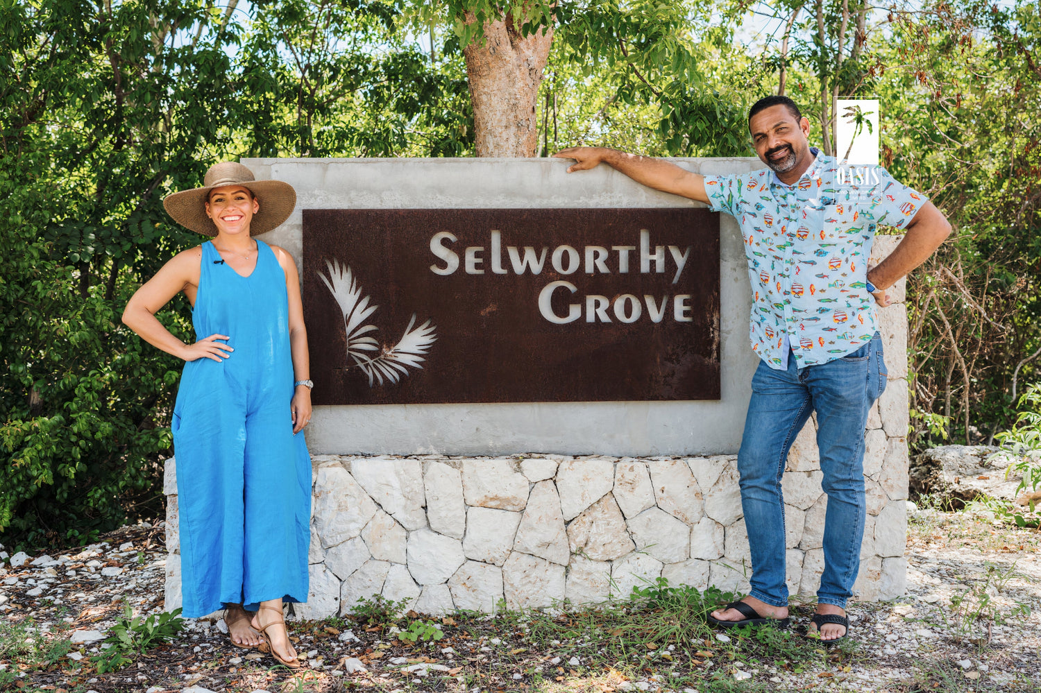 Two people standing at the entrance sign for the Selworthy Grove development in Selworthy Grove, Cayman Brac